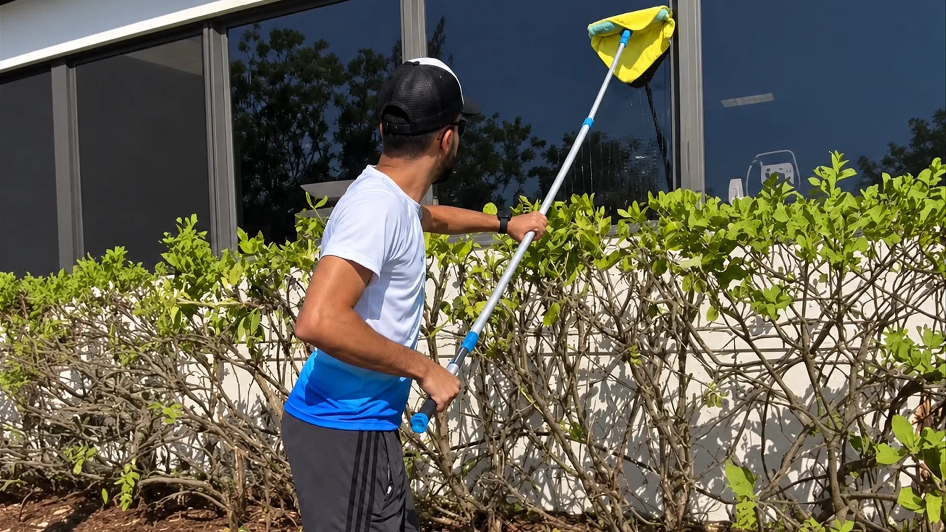 Homeowner clearing storm debris from the yard and screened patio after a hurricane in Tampa Bay